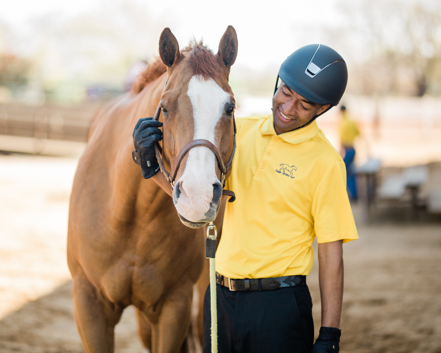 Equestrians With Disabilities rider, Spencer Roberson, pets his horse during a demonstration at the 2019 Coaches Summit.